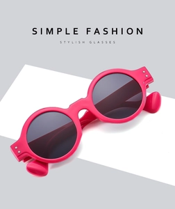 Macro view of bright pink round sunglasses with silver rivets and dark lenses