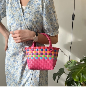 Dettaglio della borsa a cesto arcobaleno con manico fucsia e sacchetto interno a coulisse