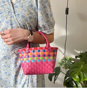 Dettaglio della borsa tote colorata intrecciata con righe e fodera con coulisse