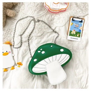 Detail of green and white mushroom-shaped cross-body bag with silver metal chain