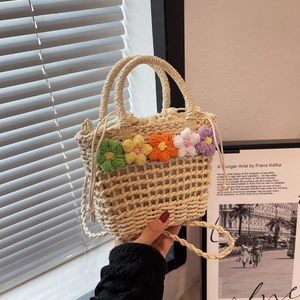 Close-up of woven straw bag with colorful floral details and drawstring lining