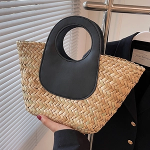 Handwoven straw bucket bag with black leather ring handles for a stylish summer look