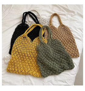 Detail of hand-woven mesh beach bags in various colors with reinforced braided handles