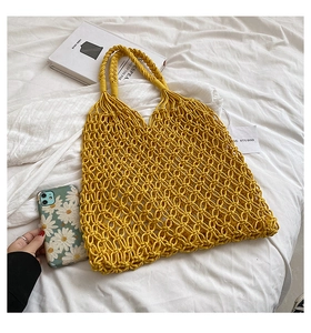 Detail view of yellow macrame hollow mesh beach tote with thick braided cotton rope handles