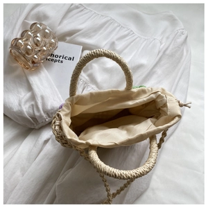 Interior detail of straw tote bag with fabric lining and secure drawstring closure