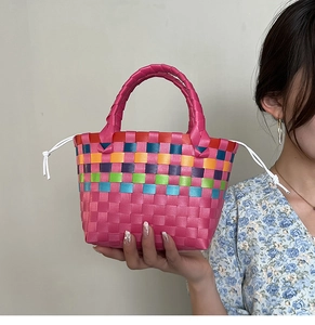 Dettaglio della borsa da spiaggia tessuta a mano con corpo rosa e bordo intrecciato arcobaleno