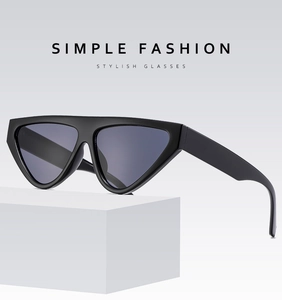 Close-up of stylish black cat eye sunglasses on white geometric display stand