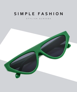 Detail view of modern cat-eye sunglasses with green geometric frame and dark lenses