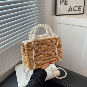 Handwoven rattan tote bag with elegant pearl top handle and long pearl chain strap