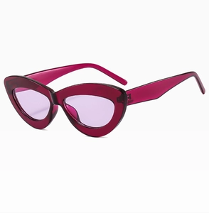 Close-up of translucent purple cat eye sunglasses with thick frames and light violet lenses