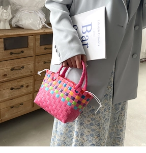 Dettaglio di una borsa a cesto intrecciata arcobaleno con fodera a coulisse e manici
