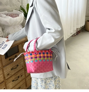 Dettaglio borsa da spiaggia intrecciata rosa con strisce colorate e chiusura a cordoncino