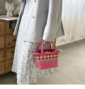 Dettaglio della borsa a cesto arcobaleno intrecciata con chiusura a coulisse bianca