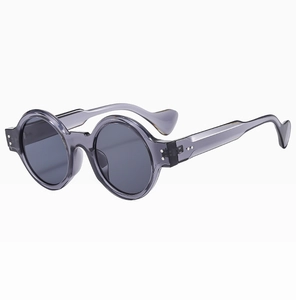 Detail of round punk sunglasses with thick grey transparent frames and tinted lenses