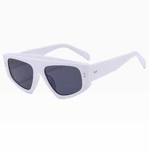 Detail view of white triangular cat-eye sunglasses with thick frame and metal accents