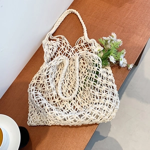 Handmade cream macrame tote bag featuring intricate hollow weave for summer beach style