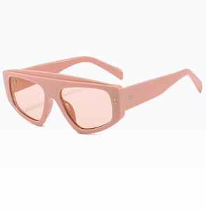 Detailed side view of oversized pink frame sunglasses with thick temples and metal dots