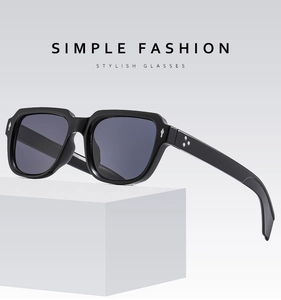 Detail einer quadratischen schwarzen Sonnenbrille mit Nieten auf weißem Ständer