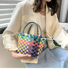Dettaglio borsa a cesto intrecciata colorata con motivo a scacchi e chiusura a coulisse