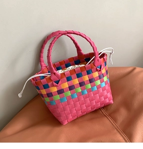 Dettaglio della borsa a cesto intrecciata rosa con strisce colorate e coulisse