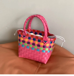 Dettaglio della borsa a cesto intrecciata a mano con righe arcobaleno e fodera interna