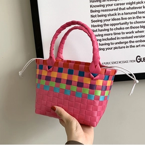 Dettaglio borsa a cesto intrecciata arcobaleno con manici rosa e chiusura a coulisse