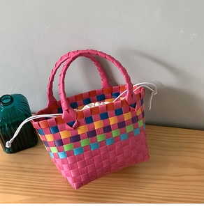 Dettaglio borsa a cesto intrecciata colorata con manici rosa e fodera a coulisse
