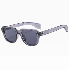 Detail der quadratischen Sonnenbrille mit Metallkreuz-Nieten und lila transparentem Rahmen