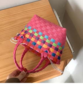 Dettaglio dell'intreccio della borsa in paglia arcobaleno con manico rosa e fodera interna