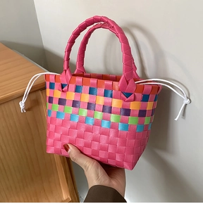 Dettaglio della borsa a cesto intrecciata a righe colorate con chiusura a coulisse