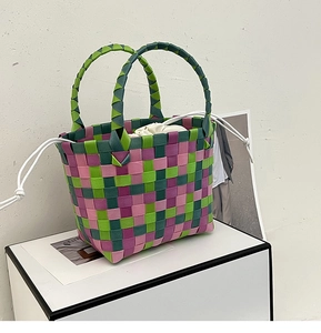 Dettaglio della borsa tote intrecciata colorata con strisce e sacchetto interno bianco