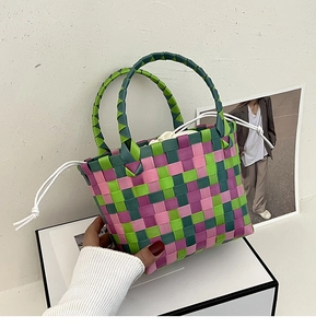 Dettaglio della borsa intrecciata rosa e verde con sacchetto interno con coulisse
