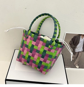 Dettaglio della borsa a mano intrecciata colorata con motivo a scacchi rosa e verdi