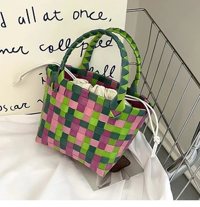 Dettaglio della borsa a cesta intrecciata rosa e verde con trama a scacchi e sacchetto