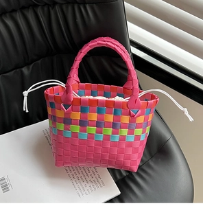 Dettaglio della borsa intrecciata arcobaleno con strisce colorate su una sedia in pelle
