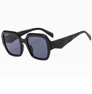 Gros plan de lunettes de soleil carrées noires avec branches texturées géométriques et monture large