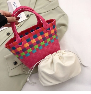 Dettaglio della borsa a cesto intrecciata colorata con motivo rosa e sacca interna con coulisse