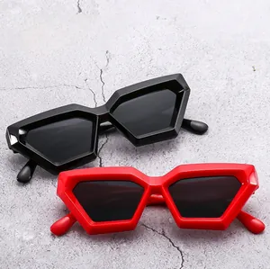 Detail of bold hexagonal geometric sunglasses in black and vibrant red frames