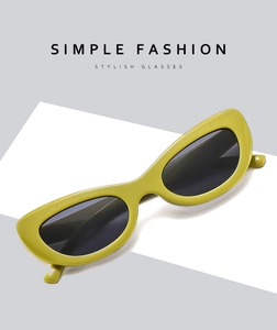 Détail de lunettes de soleil œil-de-chat vert-jaune avec verres noirs sur fond épuré