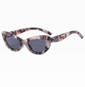 Détail de lunettes de soleil œil-de-chat à motif marbré rose avec verres gris foncé