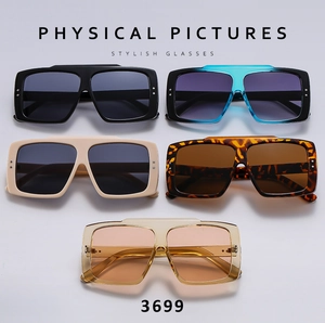 Flat lay of square oversized sunglasses showing frame details and metal rivet accents