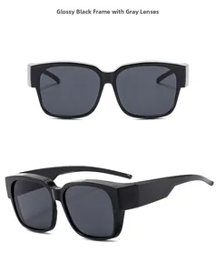 Close-up of glossy black frame sunglasses with deep grey lenses and wide temples