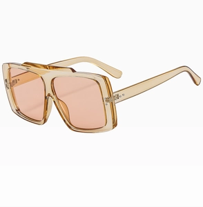 Detail of square oversized sunglasses with champagne transparent frame and coral pink lenses