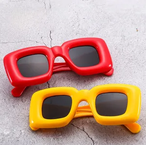 Détail de lunettes de soleil Y2K rouges et jaunes avec verres de protection UV