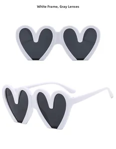Detail view of heart-shaped sunglasses with white frame and gray tinted lenses