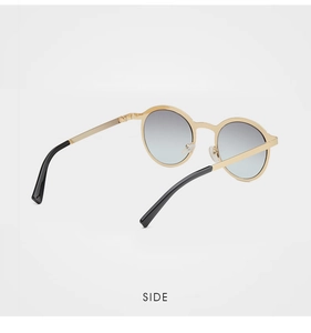 Detail view of round metal sunglasses with blue-grey gradient lenses and golden frame