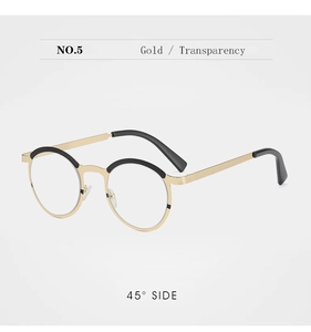 Detail view of gold metal round glasses frame with black accents and clear lenses