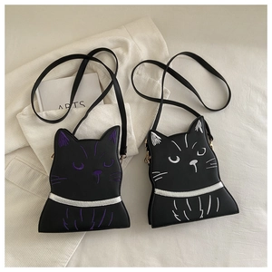 Detail of cute black cat crossbody bags with purple and white embroidery textures