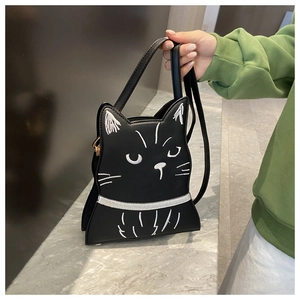 Close-up of black PU leather cat-shaped bag with white stitched face and metal hardware