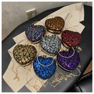 Detail of heart-shaped sequin evening bags showing various colors and gold handles